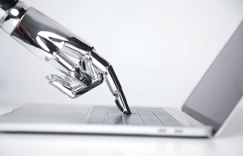 博客横幅展示了一只机械手按在笔记本电脑键盘上，以说明标题“机器翻译vs .翻译”. 人工智能会取代世界上第二古老的职业吗?"